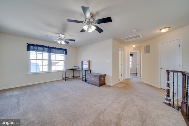 unfurnished room with a wealth of natural light, ceiling fan, and light colored carpet