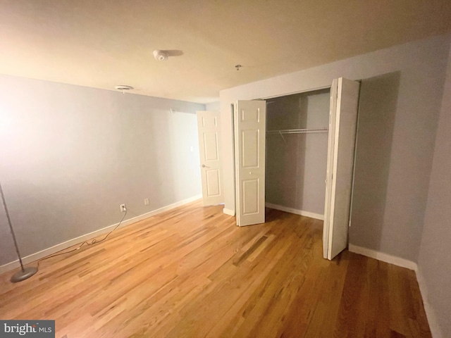 unfurnished bedroom with a closet and hardwood / wood-style floors