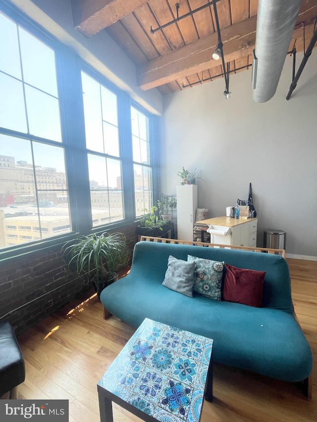 living room with beam ceiling, wood ceiling, and hardwood / wood-style flooring