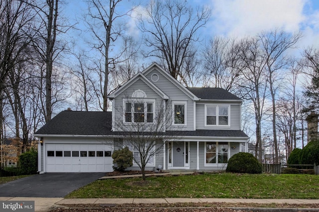 view of front of property with a garage and a front lawn