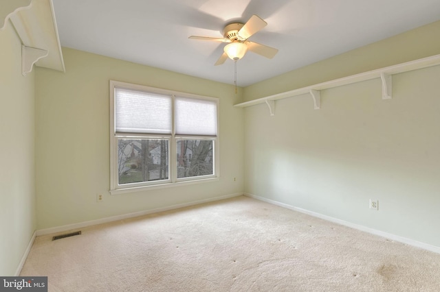 spare room featuring ceiling fan and light carpet