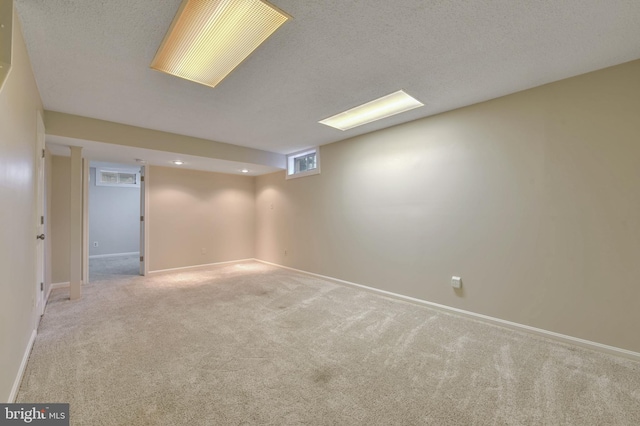 basement with a textured ceiling and light colored carpet