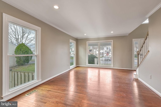 unfurnished living room featuring hardwood / wood-style floors and crown molding