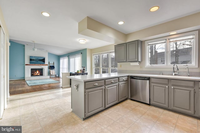 kitchen with dishwasher, kitchen peninsula, gray cabinets, and sink