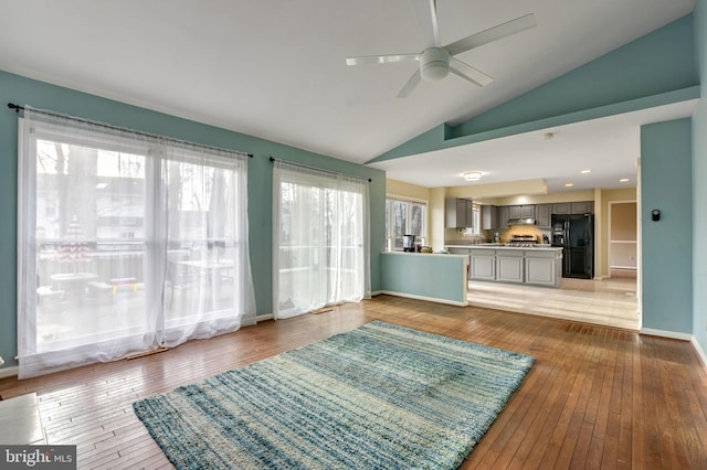 unfurnished living room with hardwood / wood-style floors, ceiling fan, and lofted ceiling