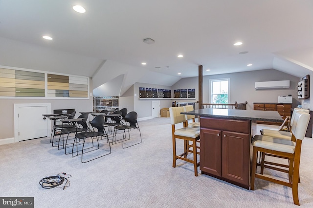 kitchen with a kitchen bar, a kitchen island, light colored carpet, and a wall mounted air conditioner