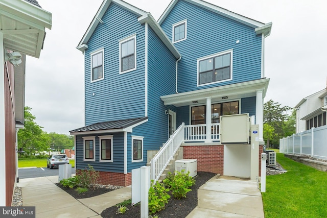 view of front of home with a porch and central air condition unit