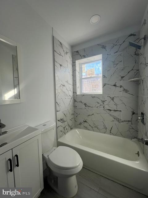 full bathroom featuring vanity, toilet, and tiled shower / bath