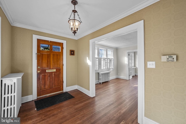 entryway with radiator, a notable chandelier, hardwood / wood-style flooring, and crown molding