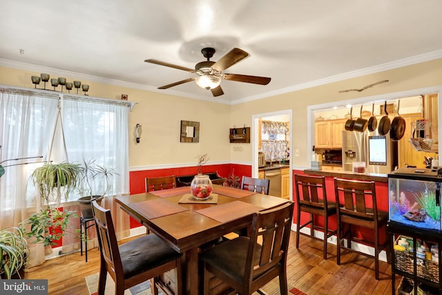 dining room with light hardwood / wood-style flooring, ceiling fan, and ornamental molding