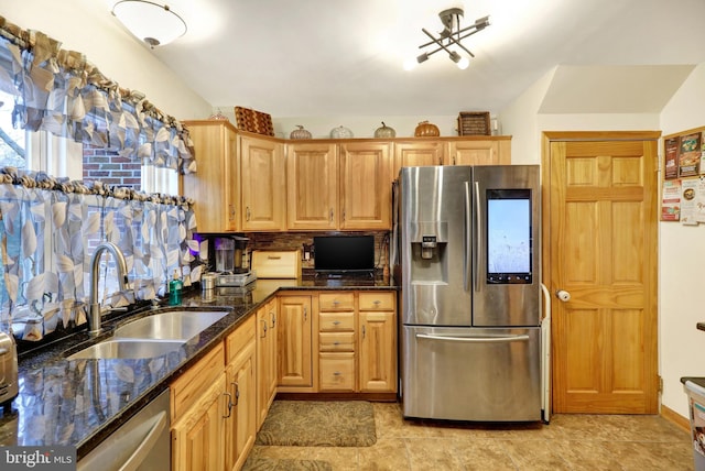 kitchen featuring backsplash, sink, stainless steel appliances, and dark stone counters