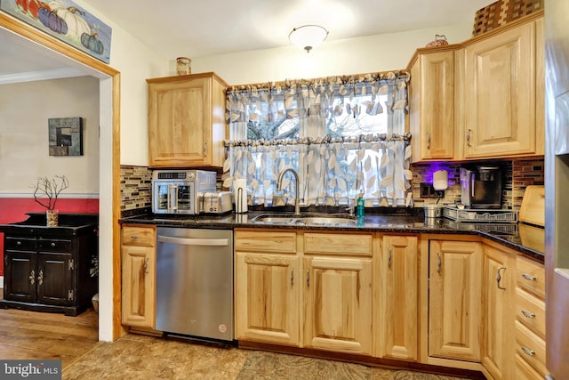 kitchen with backsplash, stainless steel dishwasher, dark stone counters, and sink