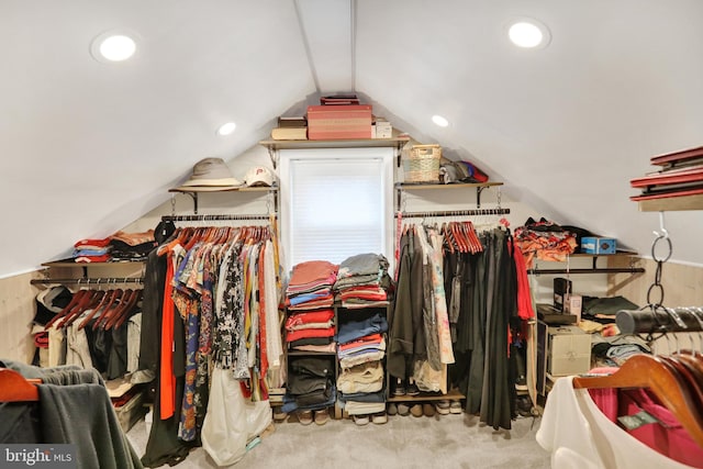 walk in closet with light carpet and vaulted ceiling