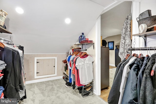 spacious closet with light colored carpet and lofted ceiling