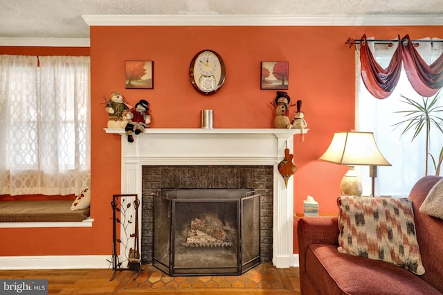 sitting room featuring hardwood / wood-style floors, a textured ceiling, crown molding, and a healthy amount of sunlight