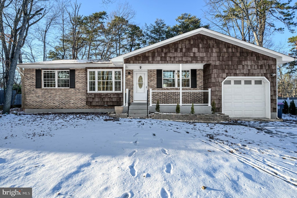 ranch-style house featuring covered porch and a garage