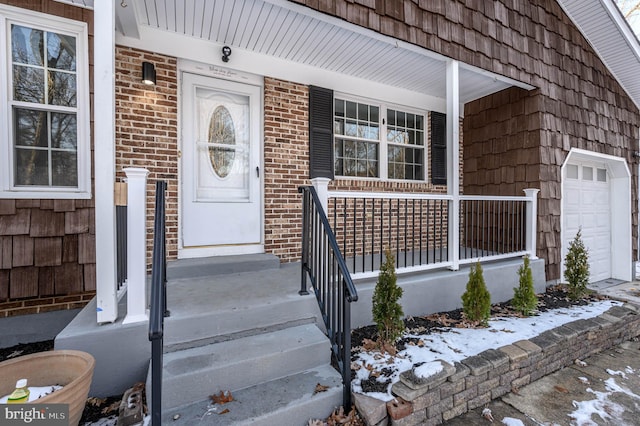 snow covered property entrance featuring covered porch