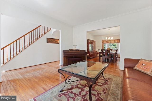 living room featuring hardwood / wood-style flooring, crown molding, and a chandelier