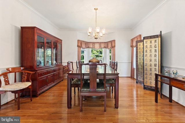 dining space featuring hardwood / wood-style floors, ornamental molding, and an inviting chandelier