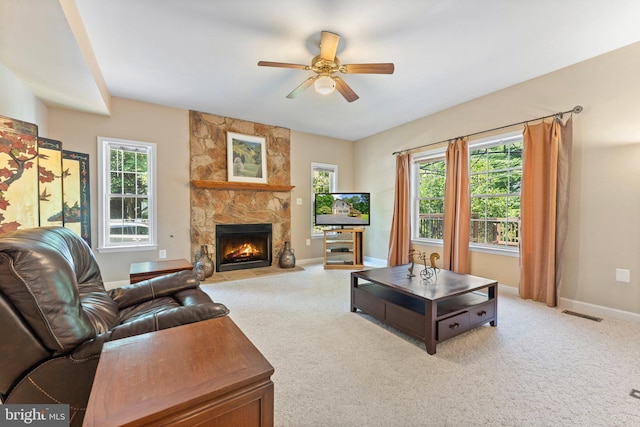 living room featuring ceiling fan, a fireplace, and carpet