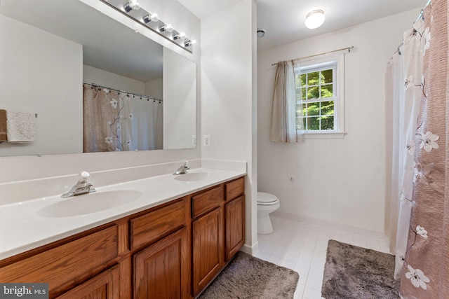 bathroom featuring tile patterned flooring, vanity, and toilet