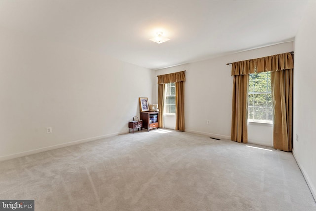 carpeted empty room featuring a wealth of natural light