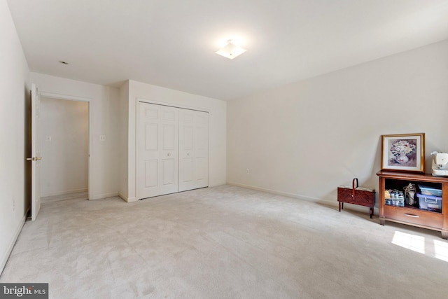 bedroom featuring light carpet and a closet