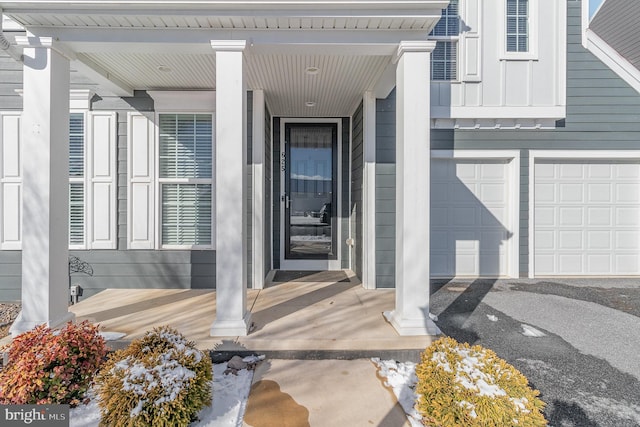 doorway to property featuring a porch and a garage