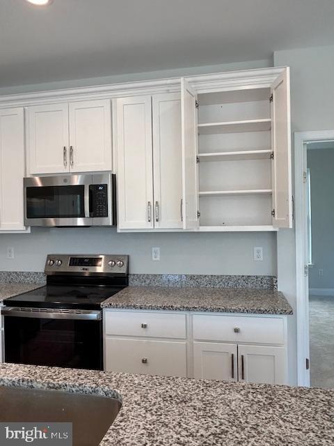 kitchen featuring white cabinets, stainless steel appliances, and stone countertops