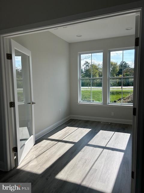 unfurnished room with dark hardwood / wood-style floors