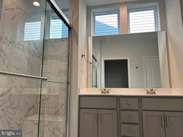 bathroom featuring vanity, a shower with door, and a healthy amount of sunlight