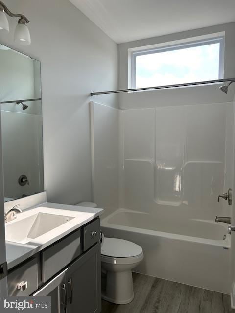 full bathroom featuring hardwood / wood-style floors, vanity, shower / bathtub combination, and toilet