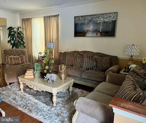 living room featuring hardwood / wood-style flooring and crown molding