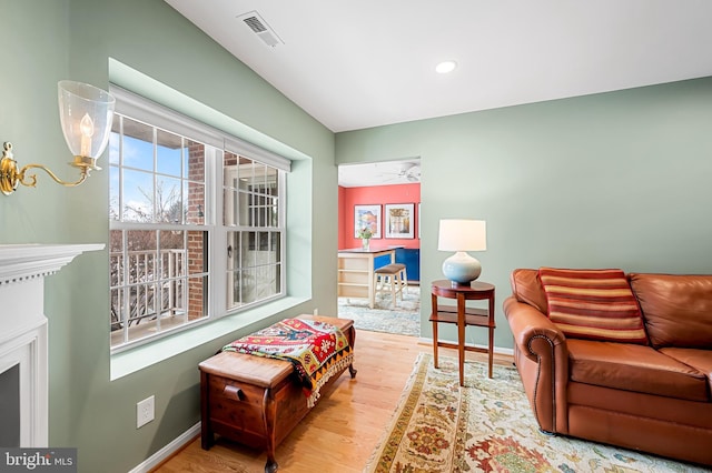 living room with ceiling fan and light hardwood / wood-style flooring