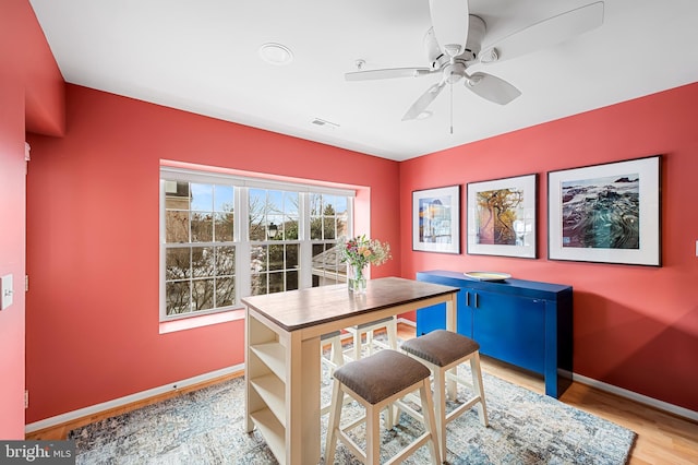 dining area with ceiling fan and light hardwood / wood-style flooring