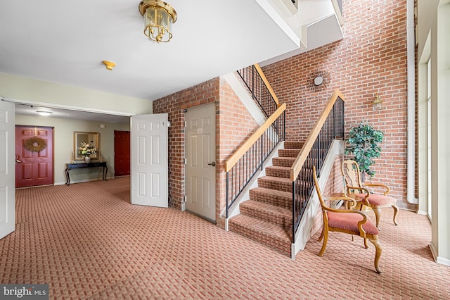 staircase with brick wall and carpet flooring