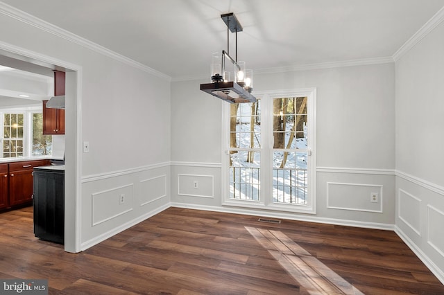 unfurnished dining area with ornamental molding, dark wood-type flooring, and a wealth of natural light