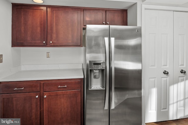 kitchen featuring stainless steel fridge with ice dispenser and light stone countertops