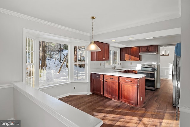 kitchen featuring pendant lighting, dark hardwood / wood-style floors, double oven range, ornamental molding, and sink