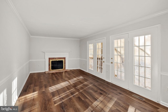 unfurnished living room featuring french doors, a brick fireplace, crown molding, and dark hardwood / wood-style floors