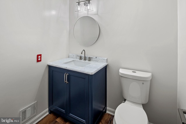 bathroom with hardwood / wood-style floors, vanity, and toilet