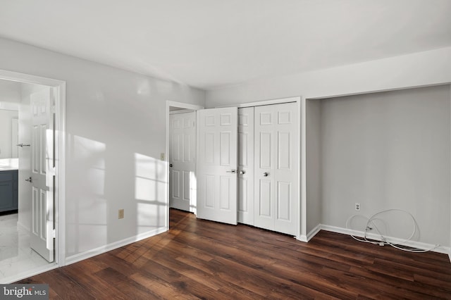 unfurnished bedroom with dark hardwood / wood-style flooring and ensuite bathroom