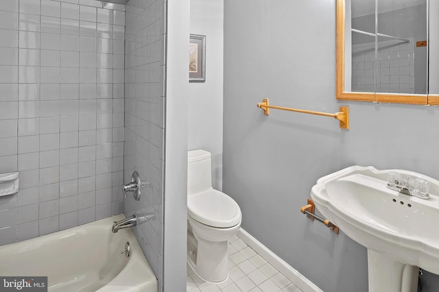 full bathroom with sink, tiled shower / bath combo, tile patterned floors, and toilet