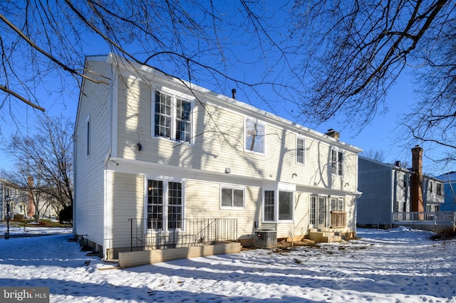 snow covered house featuring central AC