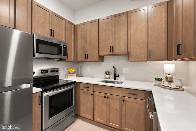 kitchen with stainless steel appliances, light stone countertops, sink, and backsplash