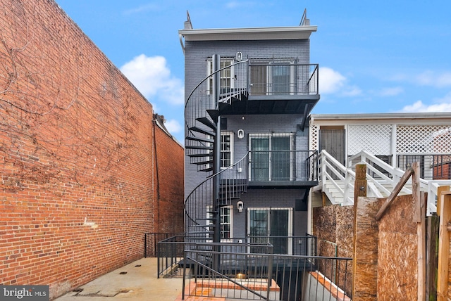 rear view of property featuring a patio and a balcony