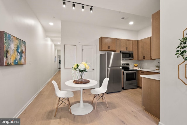 kitchen with light wood-type flooring and appliances with stainless steel finishes