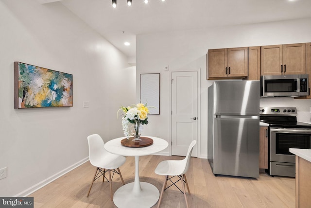 kitchen with backsplash, light wood-type flooring, and appliances with stainless steel finishes