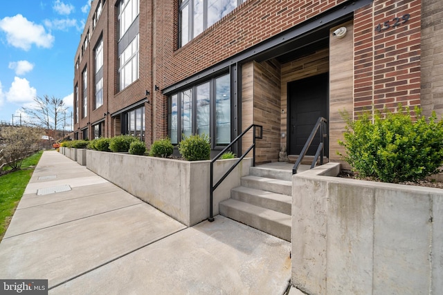 entrance to property featuring brick siding