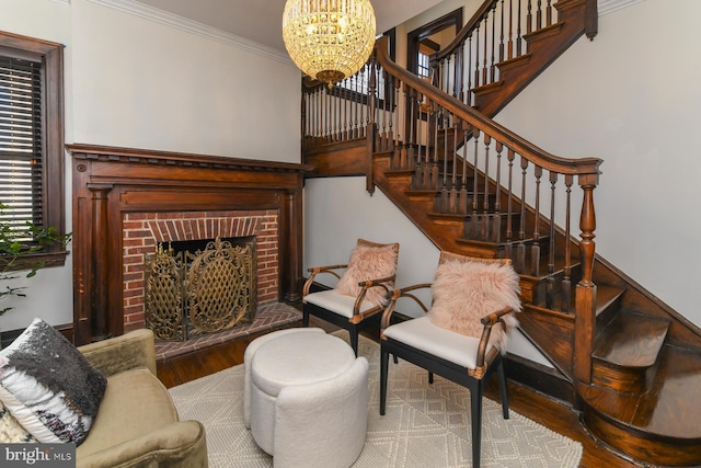 living room featuring hardwood / wood-style floors, a notable chandelier, ornamental molding, and a fireplace